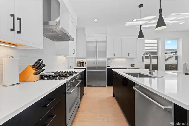 a kitchen with stainless steel appliances a sink stove and cabinets