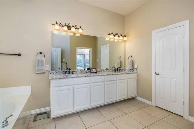 a bathroom with a double vanity sink and a mirror