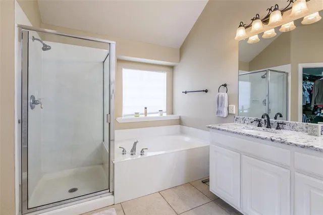 a bathroom with a granite countertop sink a mirror and shower