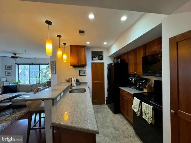 a kitchen with stainless steel appliances granite countertop a refrigerator and a microwave oven