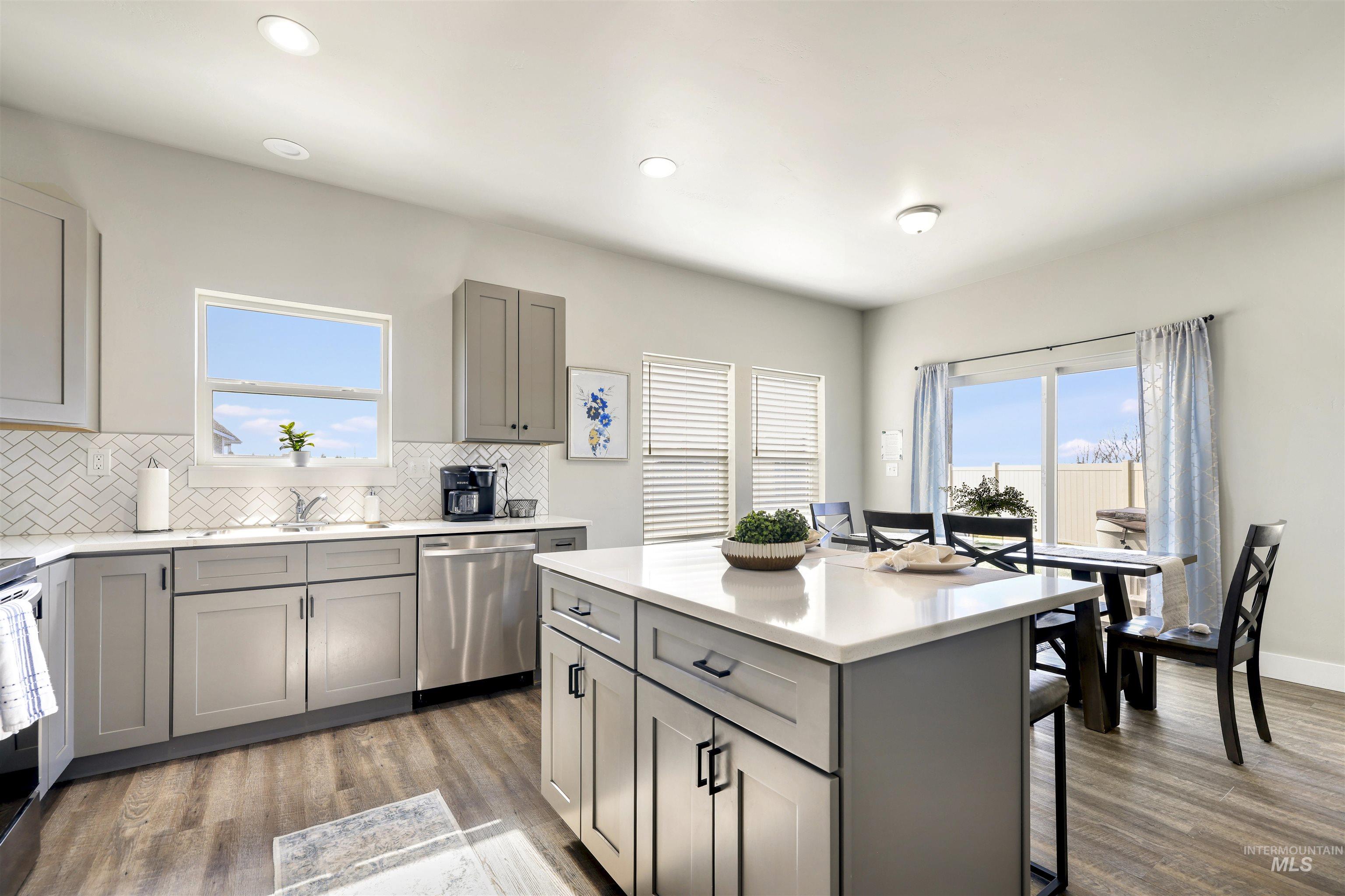 893-899 Shadowleaf Avenue Twin Falls, ID 83301 - Photo 39 of 50 Kitchen featuring gray cabinetry, a breakfast bar area, stainless steel appliances, light wood-style floors, and recessed lighting