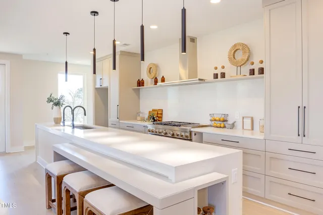 a living room with furniture kitchen view and a wooden floor
