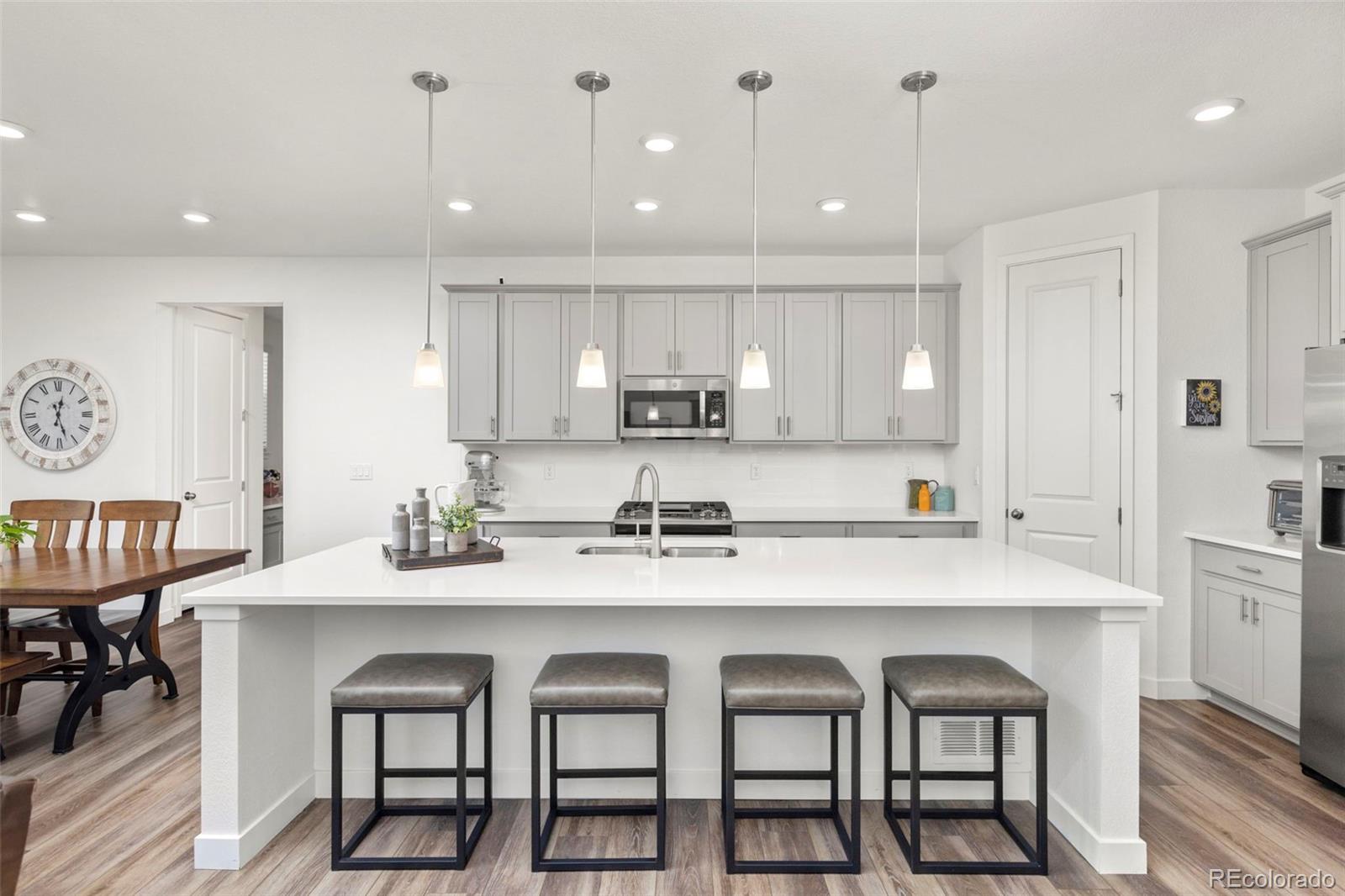 5067 Preserve Place Firestone, CO 80504 - Photo 21 of 50 a kitchen with granite countertop a table chairs stove microwave and cabinets