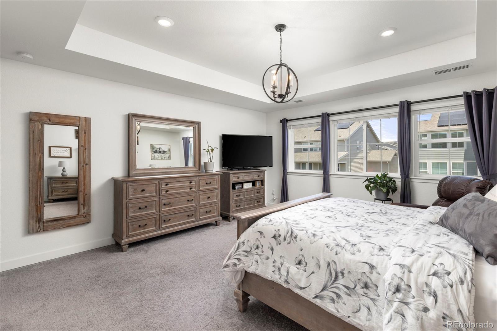 5067 Preserve Place Firestone, CO 80504 - Photo 29 of 50 a large bedroom with a large bed and a flat tv screen on dresser
