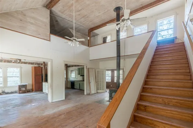 a view of a hallway with wooden floor and staircase