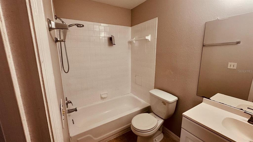 1087 South Hiawassee Road, Unit 422 Orlando, FL 32835 - Photo 3 of 17 a white toilet sitting next to a bath tub