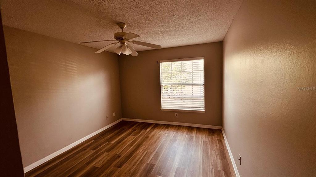1087 South Hiawassee Road, Unit 422 Orlando, FL 32835 - Photo 4 of 17 wooden floor in an empty room with a window