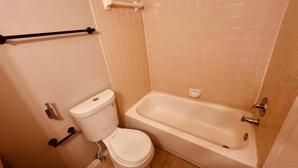 1087 South Hiawassee Road, Unit 422 Orlando, FL 32835 - Photo 8 of 17 a white toilet sitting next to a bath tub