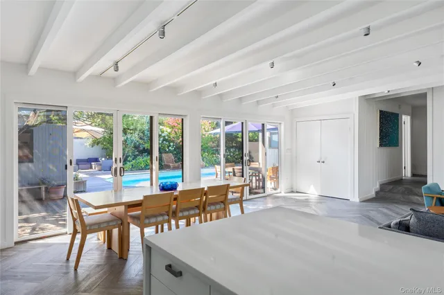 a large living room with stainless steel appliances granite countertop a sink and a large window