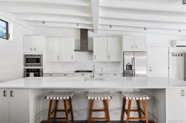 a kitchen with stainless steel appliances granite countertop a stove a sink and white cabinets