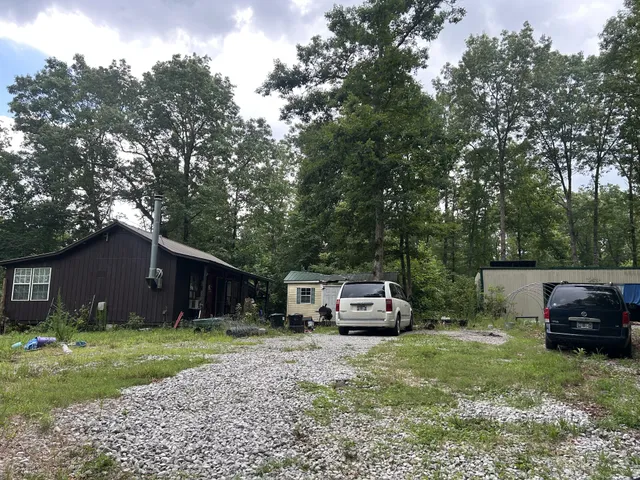 a front view of a house with a garden and trees