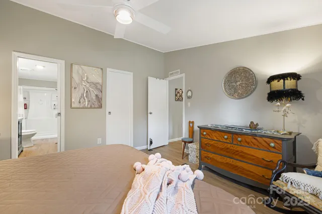 a bedroom with a bed and a lamp on dresser