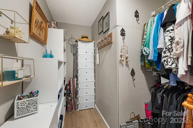 a view of walk in closet with clothes and shoes