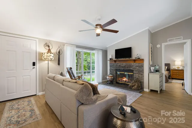 a living room with furniture floor to ceiling window and a flat screen tv