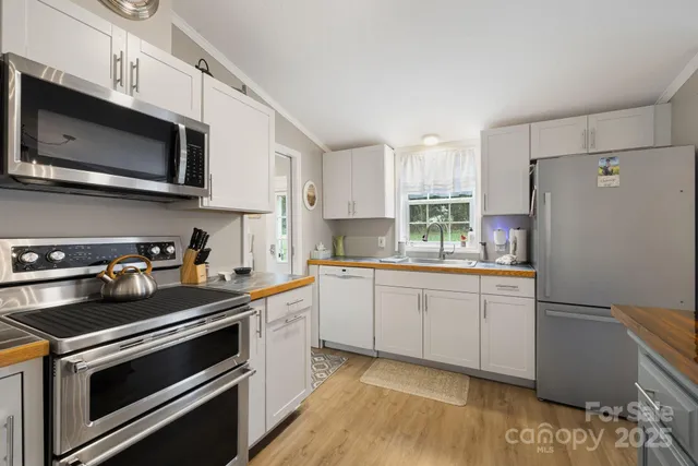 a kitchen with stainless steel appliances a stove microwave and sink