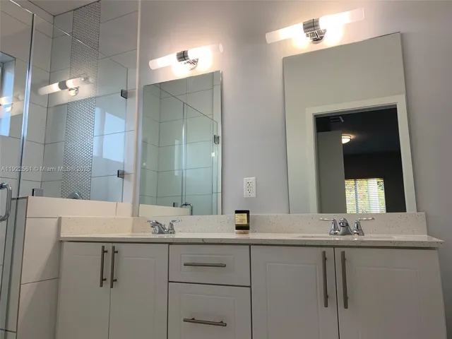 a bathroom with a sink vanity and mirror