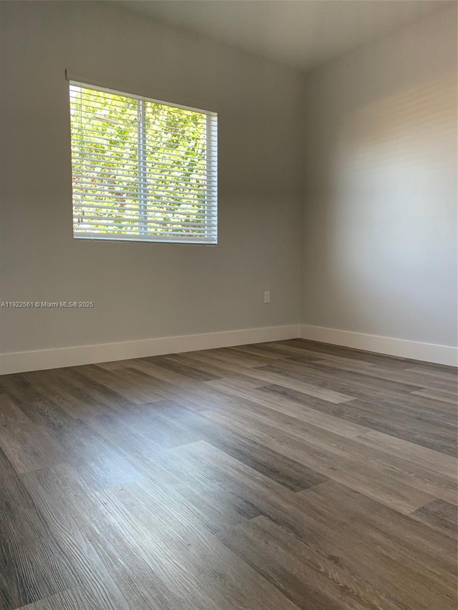 805 East 28th Street, Unit 805 Hialeah, FL 33013 - Photo 12 of 15 a view of an empty room with wooden floor and a window
