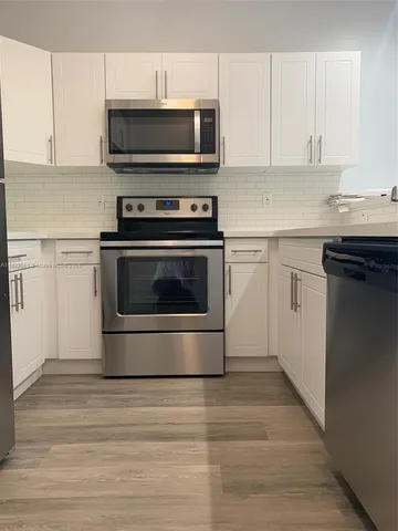a kitchen with granite countertop a stove and a microwave