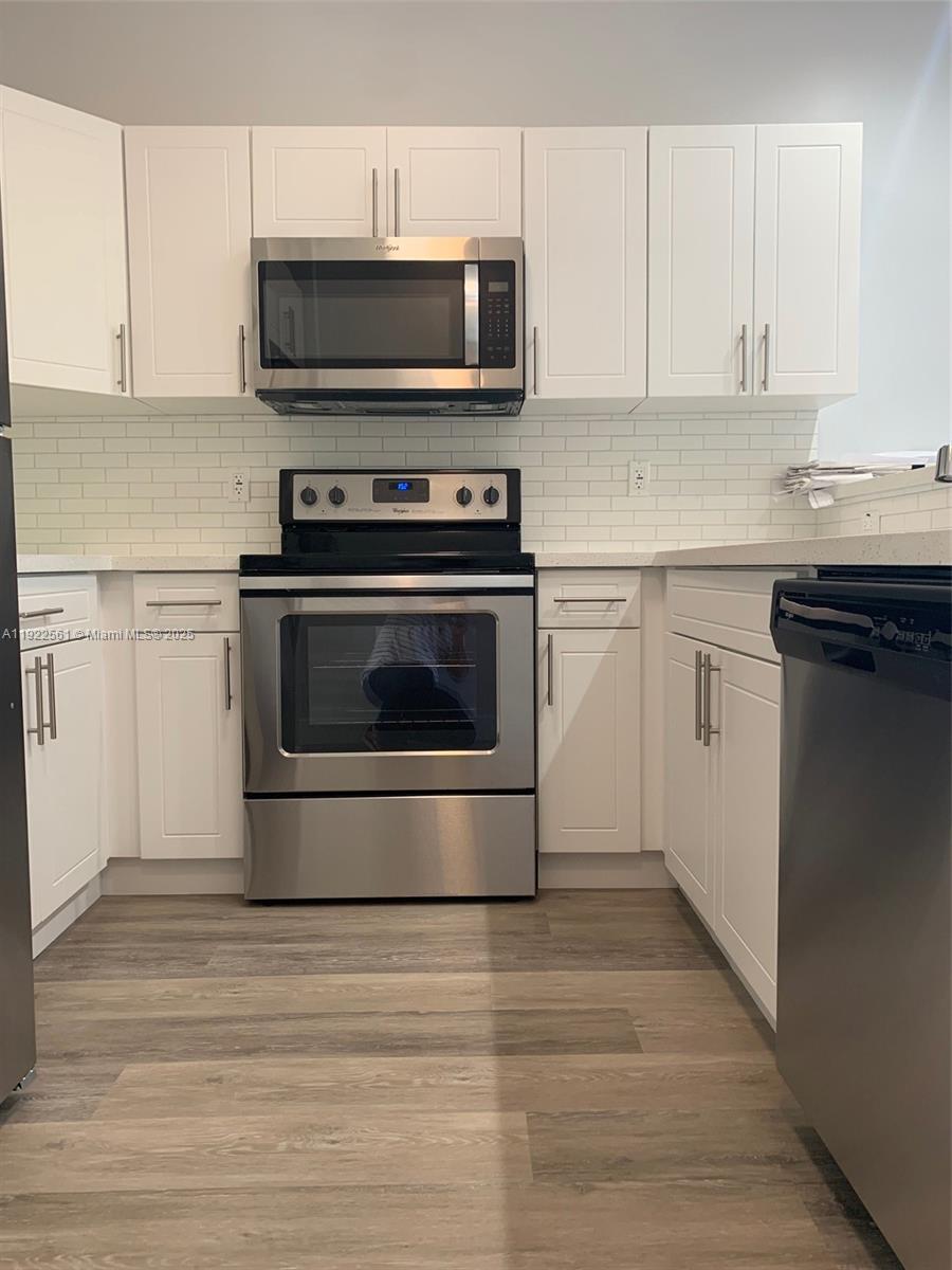805 East 28th Street, Unit 805 Hialeah, FL 33013 - Photo 5 of 15 a kitchen with granite countertop a stove and a microwave