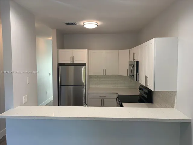 a kitchen with a refrigerator and a stove