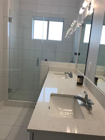 a bathroom with a sink a mirror and shower