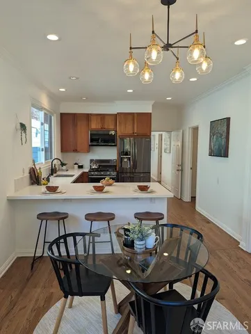 a kitchen with a dining table chairs and refrigerator