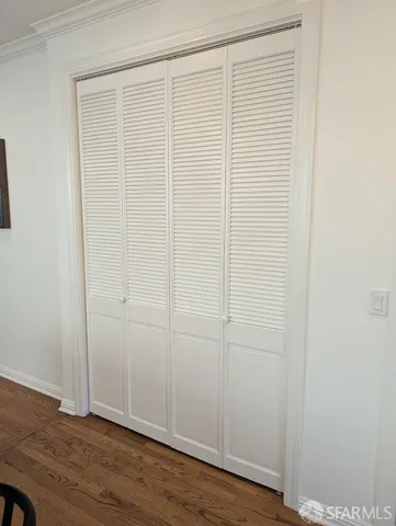 a view of an empty room with wooden floor