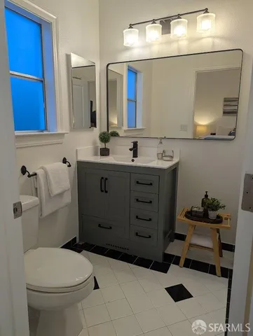 a bathroom with a toilet sink vanity and mirror