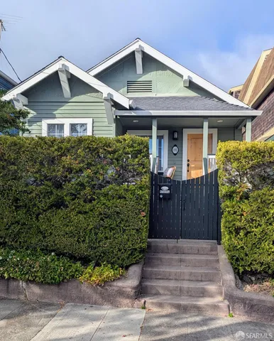 a front view of a house with a yard and potted plants