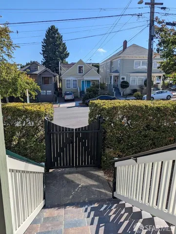 a view of a street with brick wall and plants