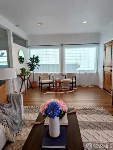 a living room with furniture and wooden floor