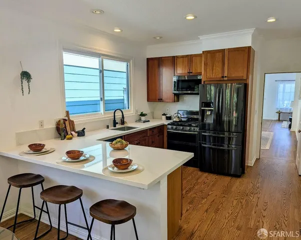 a kitchen with stainless steel appliances a sink a stove a refrigerator and cabinets