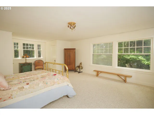 a bedroom with a bed and large window with outer view