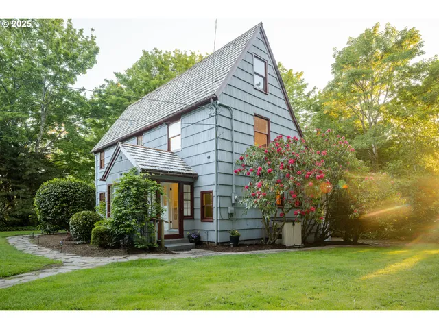 a front view of house with yard and trees in the background