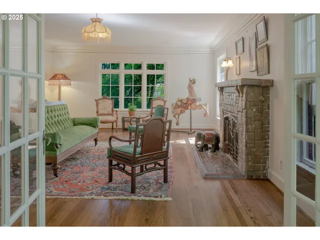 a living room with furniture a fireplace and a floor to ceiling window