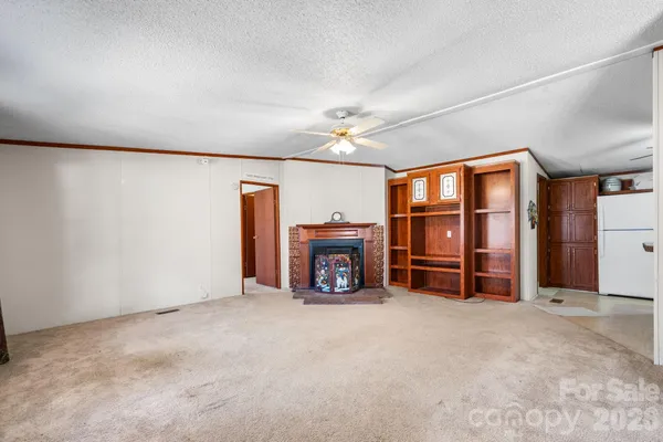 a view of an empty room with a fireplace and a window