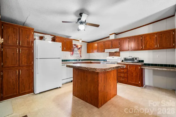 a kitchen with stainless steel appliances granite countertop a refrigerator a oven a sink a stove and a refrigerator
