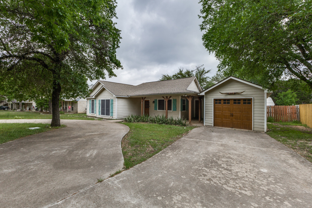 Ranch-style house with fence, roof with shingles, a garage, a front yard, and concrete driveway