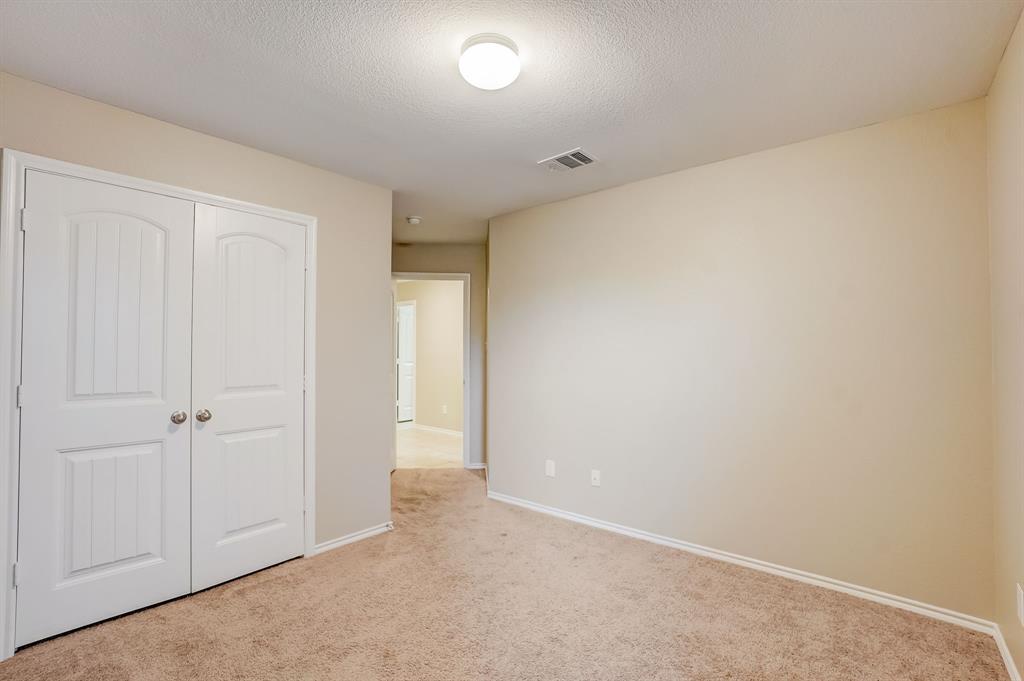 2113 Rubin Road Fate, TX 75189 - Photo 21 of 37 Unfurnished bedroom featuring a closet, light colored carpet, and a textured ceiling