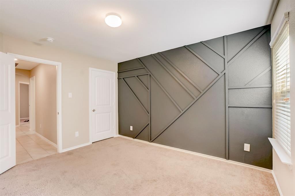 2113 Rubin Road Fate, TX 75189 - Photo 23 of 37 Unfurnished bedroom with carpet flooring, a closet, and a decorative wall