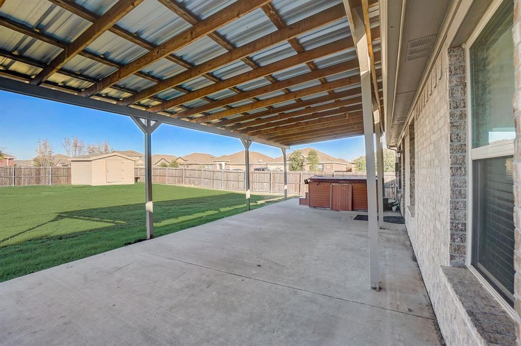 2113 Rubin Road Fate, TX 75189 - Photo 24 of 37 Fenced backyard with a hot tub, a patio area, a storage shed, and a residential view