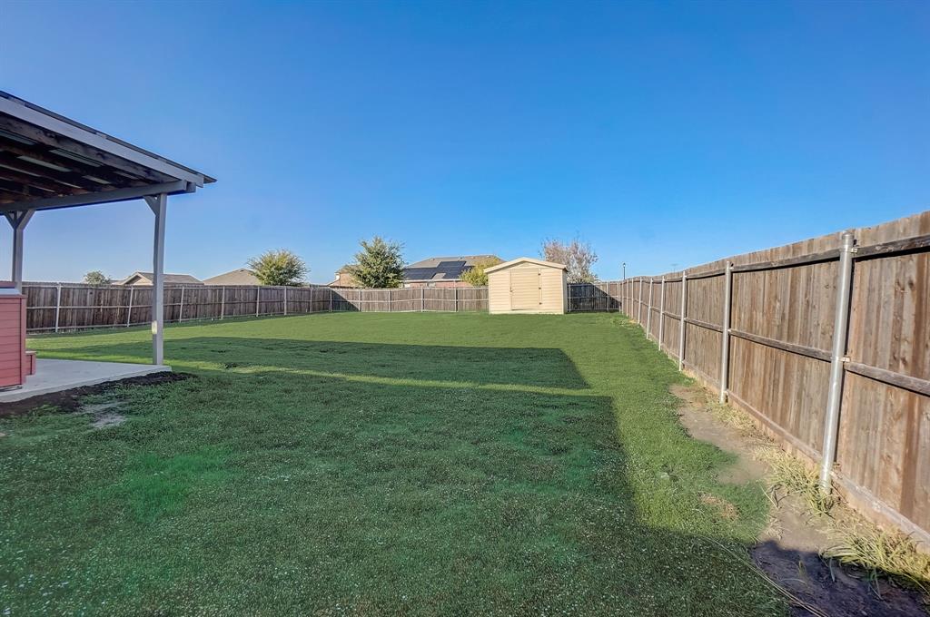 2113 Rubin Road Fate, TX 75189 - Photo 26 of 37 Fenced backyard with a storage shed and a patio