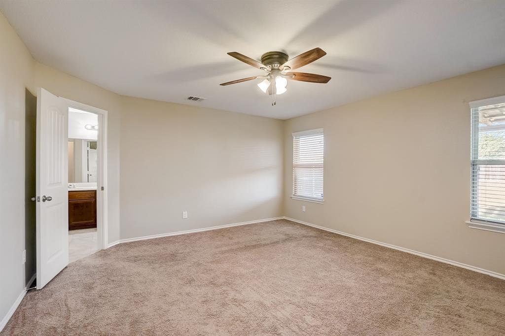 2113 Rubin Road Fate, TX 75189 - Photo 9 of 37 Unfurnished bedroom featuring light colored carpet, multiple windows, ceiling fan, and ensuite bathroom