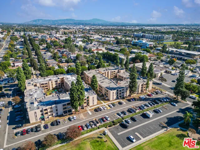 a view of a storage & utility room with refrigerator and wooden floor