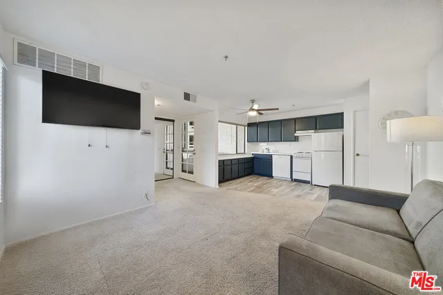 a living room with furniture and kitchen view