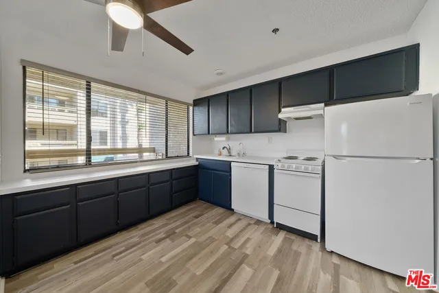 a kitchen with a sink a stove a refrigerator and a window