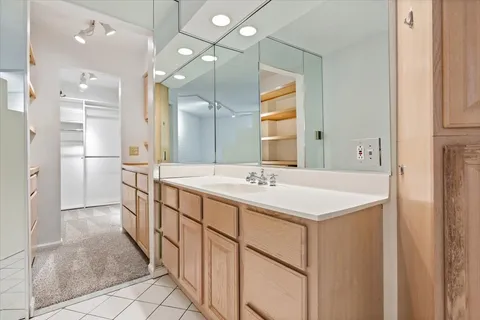 a bathroom with a double vanity sink mirror and refrigerator