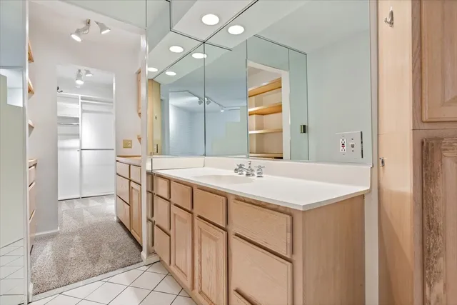 a bathroom with a double vanity sink mirror and refrigerator
