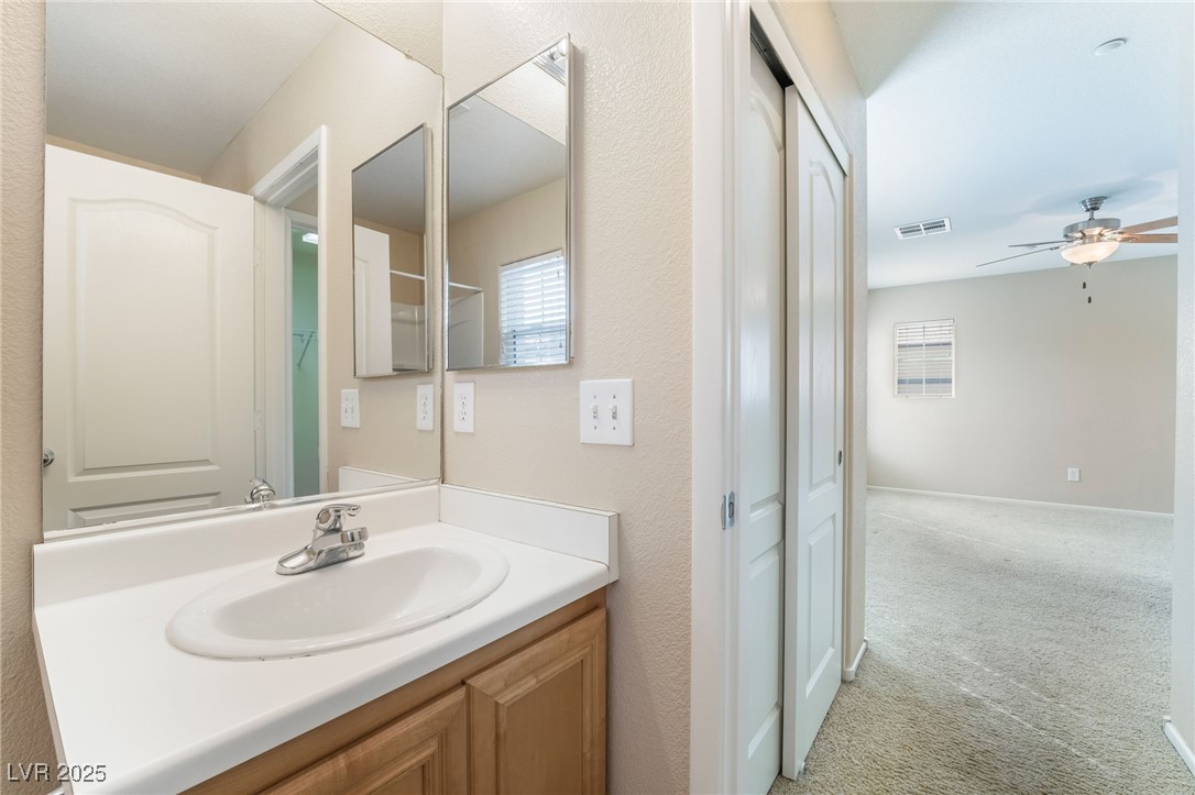 1152 Gecko Road Henderson, NV 89002 - Photo 17 of 32 Bathroom featuring baseboards, visible vents, a ceiling fan, and vanity