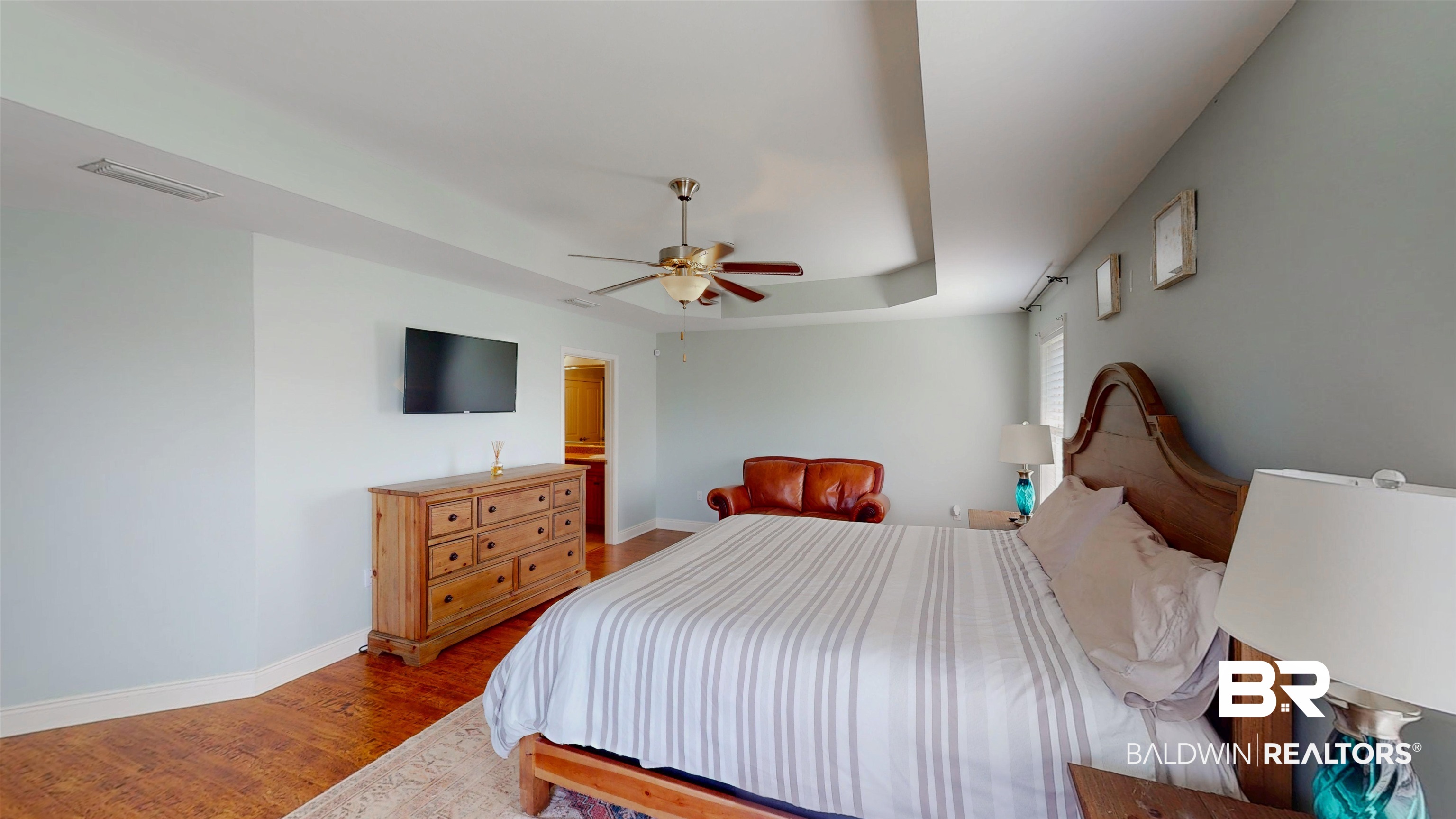 1704 Arcadia Drive Foley, AL 36535 - Photo 27 of 52 Bedroom with wood finished floors, a tray ceiling, and a ceiling fan